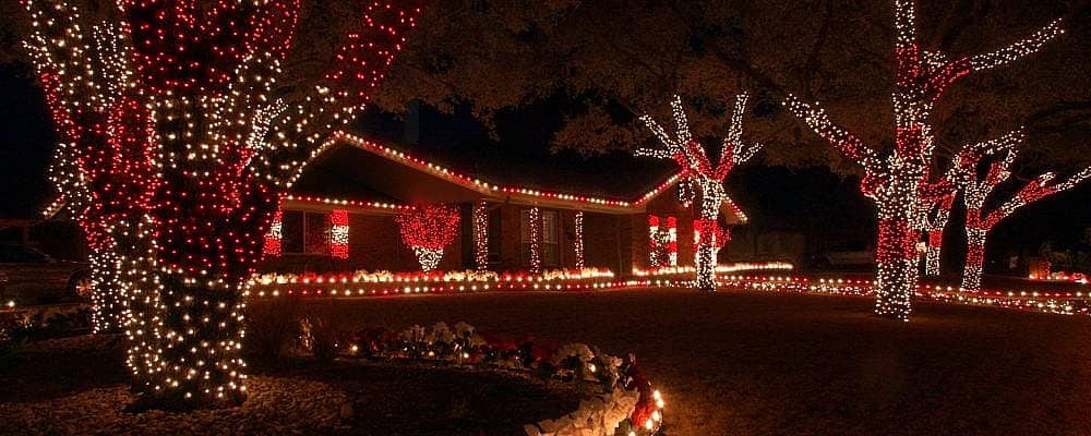 Red and white holiday lights is the color theme for this home and yard.